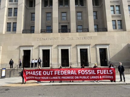Activists holding a banner outside the U.S. Department of the Interior: Phase out federal fossil fuels